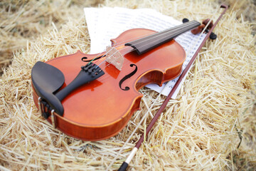 One violin and bow placed on a pile of straw in the field. Music Violin training