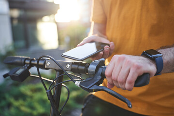 Male with smartphone using ecological transport outdoors