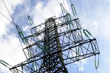 power line pole against a blue sky with clouds