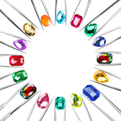 Frame of tweezers with different shiny gemstones on white background