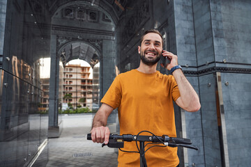 Happy guy making call while riding in city