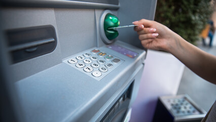 hand puts credit card into ATM