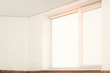 Window with blinds in room on sunny day