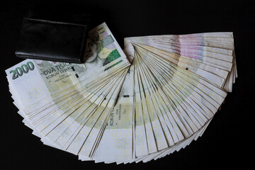 Czech money in a black wallet on a black background. Czech crowns.