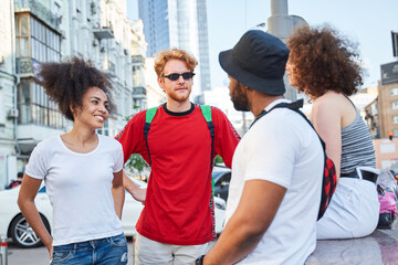 Cheerful young people communicating in urban street