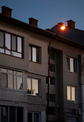 Old building with windows at sunset and electric lamp