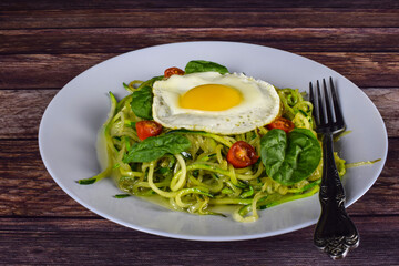 zucchini  noodles top with egg spinach and tomatoes