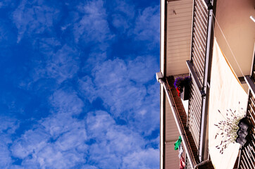 Balconies in the late summer sun against a blue sky with dissipating clouds