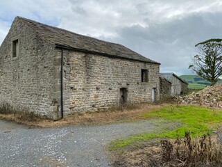 Fototapeta na wymiar An old stone barn, with a shed and rubble, near, Malham, Skipton, UK