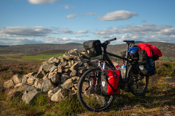 travel bike in the mountains. fully equipped with bags and cycling gear. Scotland