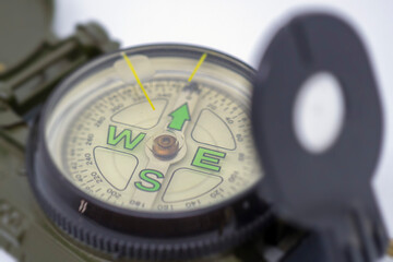 Closeup green color military compass on isolated white background.