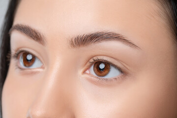 Eyebrows of a young teenager girl after plucking and cutting close-up. The make-up artist will do permanent eyebrow makeup. Makeup and cosmetology concept, eyebrow shape modeling.