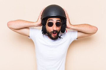 young cool bearded man surprised with a helmet. motorbike rider