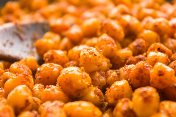 Cooking chickpeas with spices in a pan, close-up