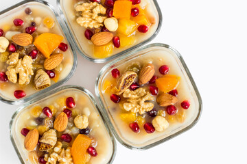 Traditional Turkish Dessert Ashura or Noah's Pudding in glass bowls on white with copy space.