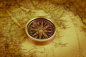 Fototapeta na wymiar Compass on a vintage world map. Retro style