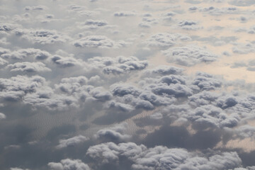white clouds over the blue ocean, view from the plane window