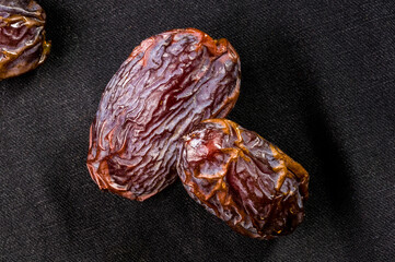 Big luxury dried date fruit on the dark surface, kurma ramadan kareem concept, close up.