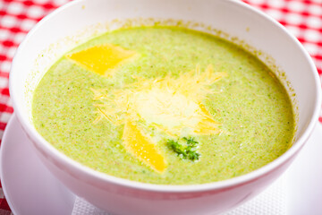 Broccoli cream soup with cheese in white bowl. Close up