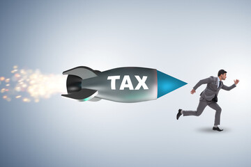 Obraz premium Concept of tax with businessman chased by rocket