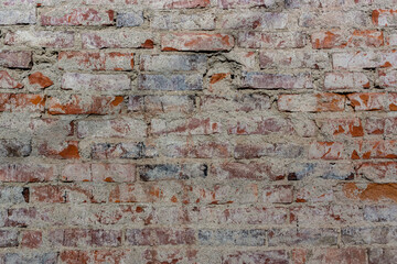 Old red bricks of dirty wall background with broken white coating