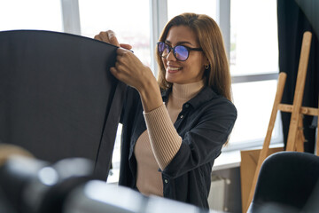 Happy young woman fixing soffits in studio