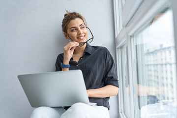 Happy pretty woman using notebook at home