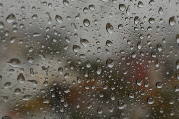 Raindrops on a misted glass with a soft multi-colored background
