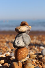 beautiful balance of stones by the sea on a background of blue sky