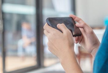 The boy is playing online games in his mobile phone, which is the technology age nowadays.