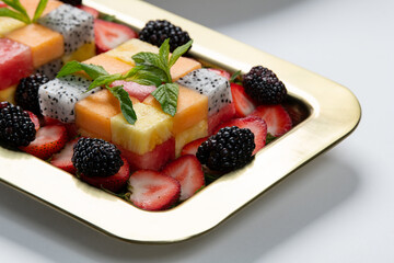 Assortment of healthy raw fruits and berries platter background, strawberries raspberries oranges plums apples kiwis grapes blueberries, mango, top view, selective focus