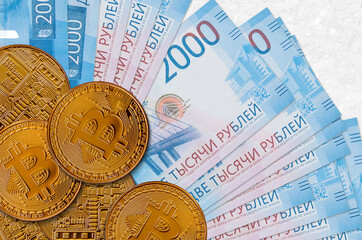 2000 russian rubles bills and golden bitcoins. Cryptocurrency investment concept. Crypto mining or...