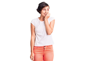 Fototapeta premium Beautiful young woman with short hair wearing casual clothes looking stressed and nervous with hands on mouth biting nails. anxiety problem.