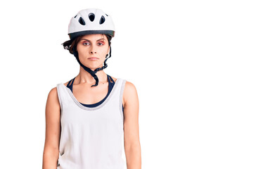 Beautiful young woman with short hair wearing bike helmet with serious expression on face. simple and natural looking at the camera.