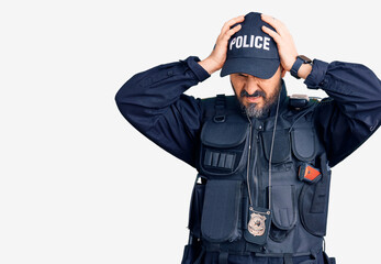 Young handsome man wearing police uniform suffering from headache desperate and stressed because pain and migraine. hands on head.