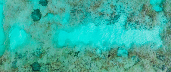 Fototapeta na wymiar An aerial view of the beautiful Mediterranean sea, where you can se the rocky textured underwater corals and the clean turquoise water of Cyprus, Horizontal Shot for banner or backround