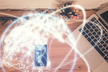 Double exposure of business theme hologram over desktop with phone. Top view. Mobile international trade connection concept.