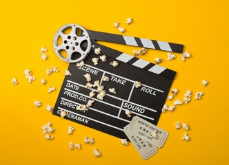 Single, black, open movie clapper or clapper-board with film reel, popcorn and movie theatre...