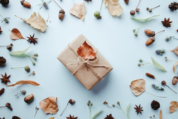 Autumn holidays preparation and creativity layout for greeting card. Festive decorations, gift box, acorns and dry leaves, flat lay with empty space for text design