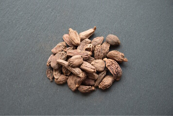 Black cardamon (brown cardamom, Amomum subulatum) on grey background