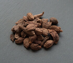 Black cardamon (brown cardamom, Amomum subulatum) on grey background