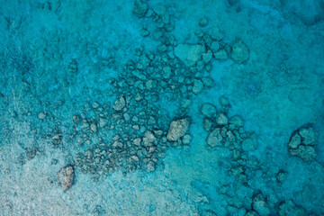 An aerial view of the beautiful Mediterranean sea, where you can se the rocky textured underwater corals and the clean turquoise water of Cyprus
