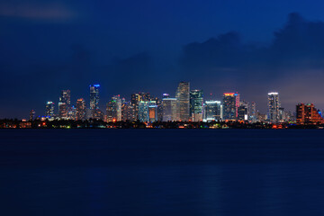 Fototapeta na wymiar Skyline city miami lighting lights sea ocean sunset night cityscape buildings downtown, architecture skyscraper dusk panorama. Miami.