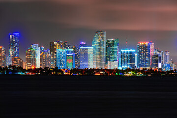 Fototapeta na wymiar Skyline city miami lighting lights sea ocean sunset night cityscape buildings downtown, architecture skyscraper dusk panorama. Miami night downtown.