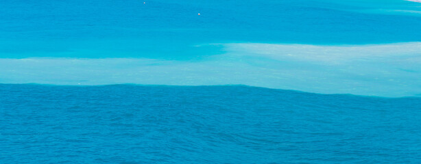 Obraz premium a horizontal panoramic shot of an amazing view of the sea split in three colors blue , white and turquiose 