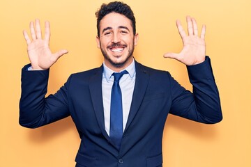 Young hispanic man wearing suit showing and pointing up with fingers number ten while smiling confident and happy.