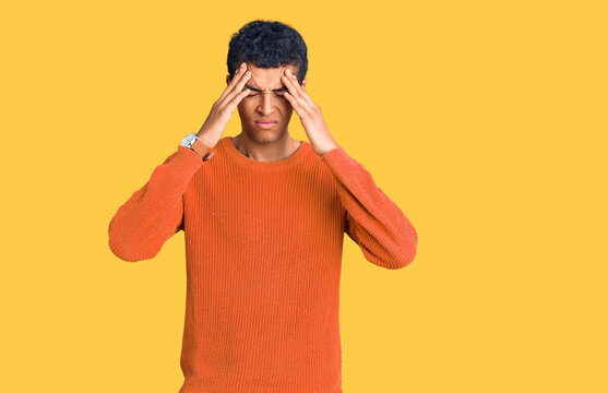 Young african amercian man wearing casual clothes suffering from headache desperate and stressed because pain and migraine. hands on head.