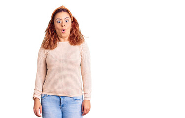 Young latin woman wearing casual clothes and diadem afraid and shocked with surprise expression, fear and excited face.