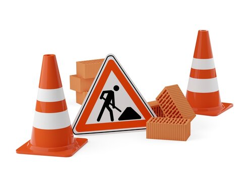 Orange traffic warning cones or pylons with street or road construction sign and stone bricks on white background - under construction, maintenance or attention concept