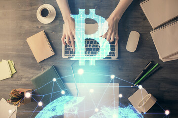 Double exposure of woman hands working on computer and blockchain theme hologram drawing. Top View. bitcoin cryptocurrency concept.